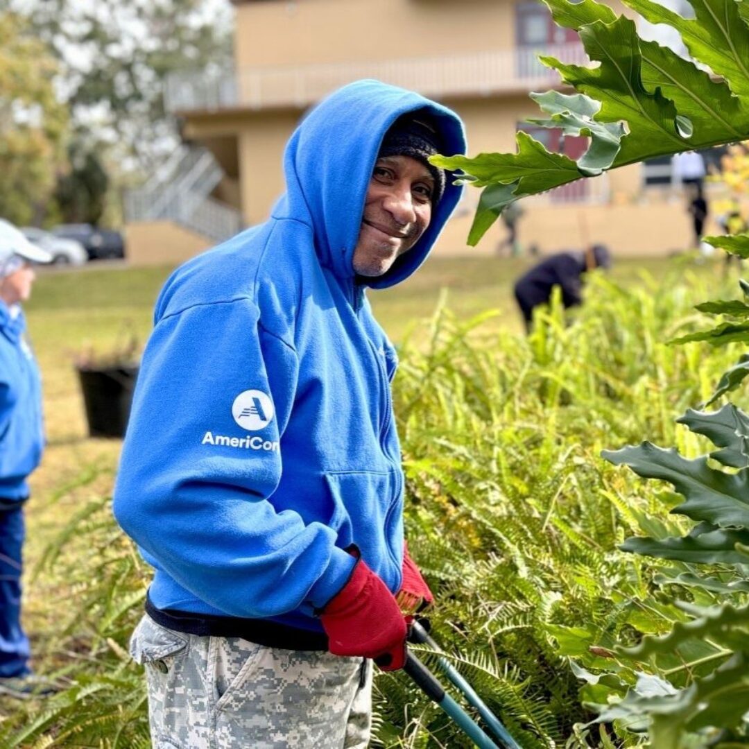 AmeriCorps Seniors volunteer clears landscaping during a community beautification project with Seniors in Service volunteers.