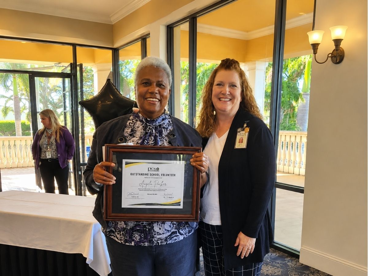 Angela, a Seniors in Service Lunch Pal volunteer and Outstanding Mentor of the Year recipient, poses with her award recognizing her impact on student mentorship and educational success.