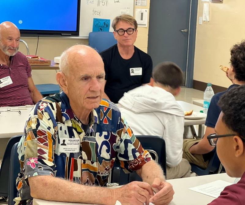 Volunteer mentor talks with a Ben Hill Middle School student during a pizza mentoring session focused on confidence, goals, and life skills.