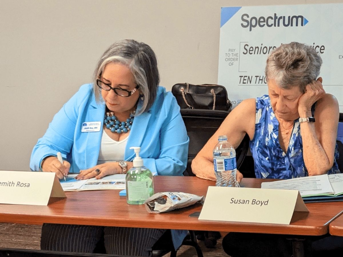 Seniors in Service board members Jemith and Susan take notes during board retreat training and strategic planning discussions.
