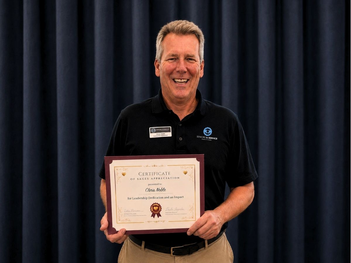 Seniors in Service Director of Community Engagement Chris Noble holding SAGES Golden Hearts Leadership Award certificate.