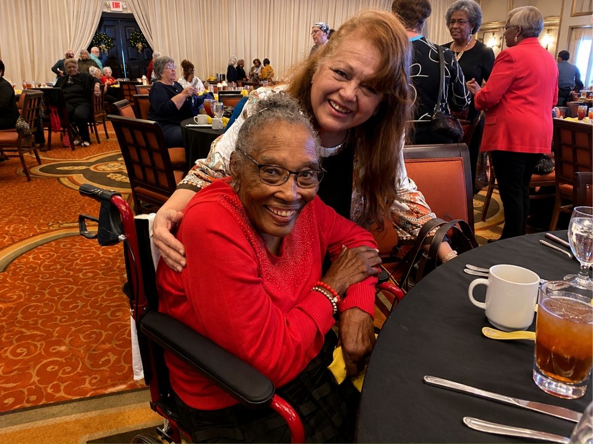 Classroom Grandparent volunteer Marsha Hypolite smiles with Senior Companion volunteer Theresa during a volunteer appreciation gathering.