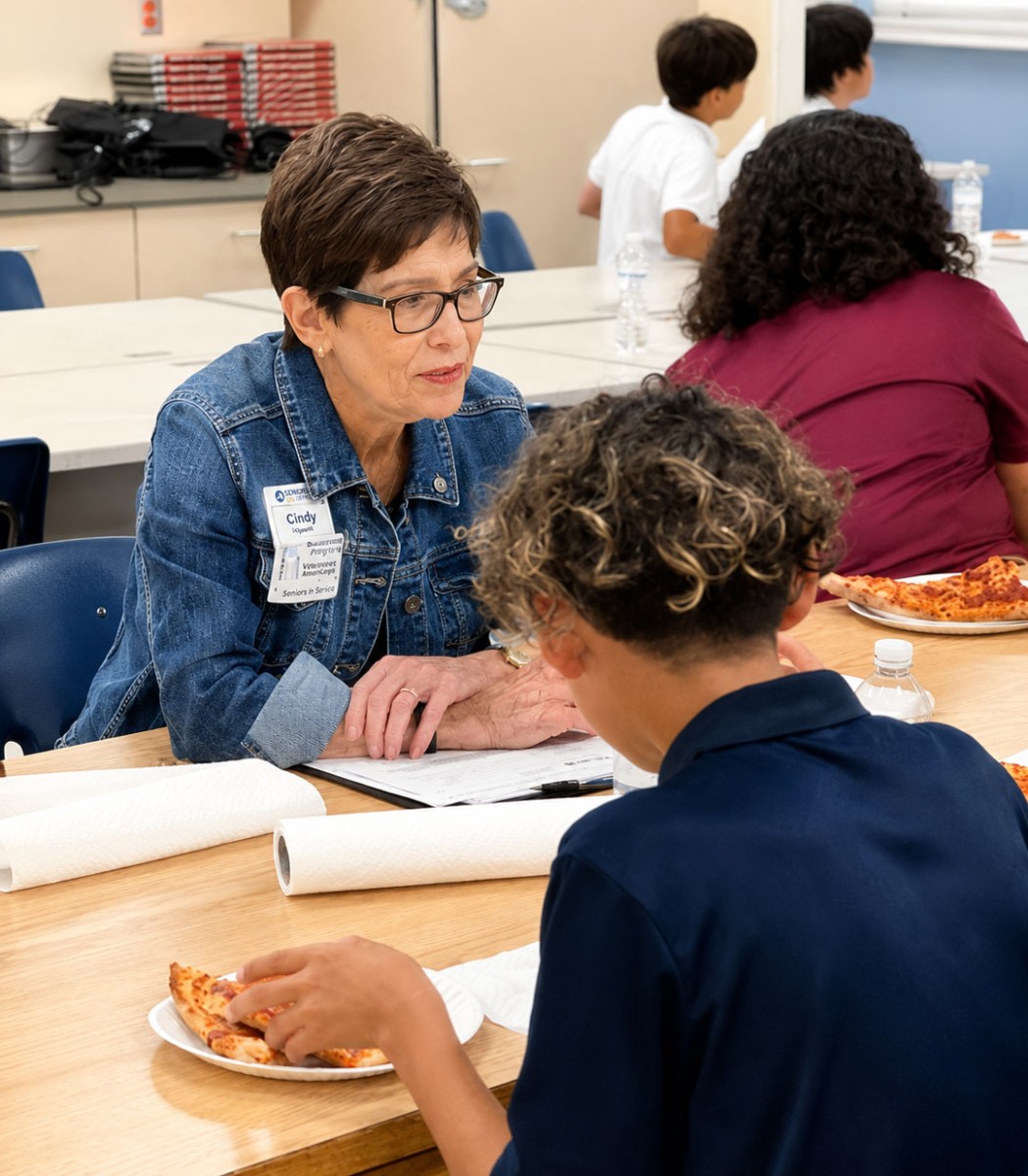 Volunteer mentor speaks with a student during a group mentoring session focused on encouragement, connection, and personal growth.