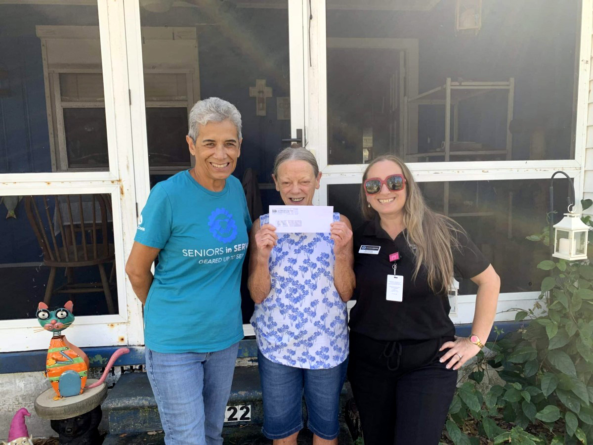 Senior receives disaster relief assistance from Seniors in Service volunteers following hurricane damage in Gulfport, Florida.