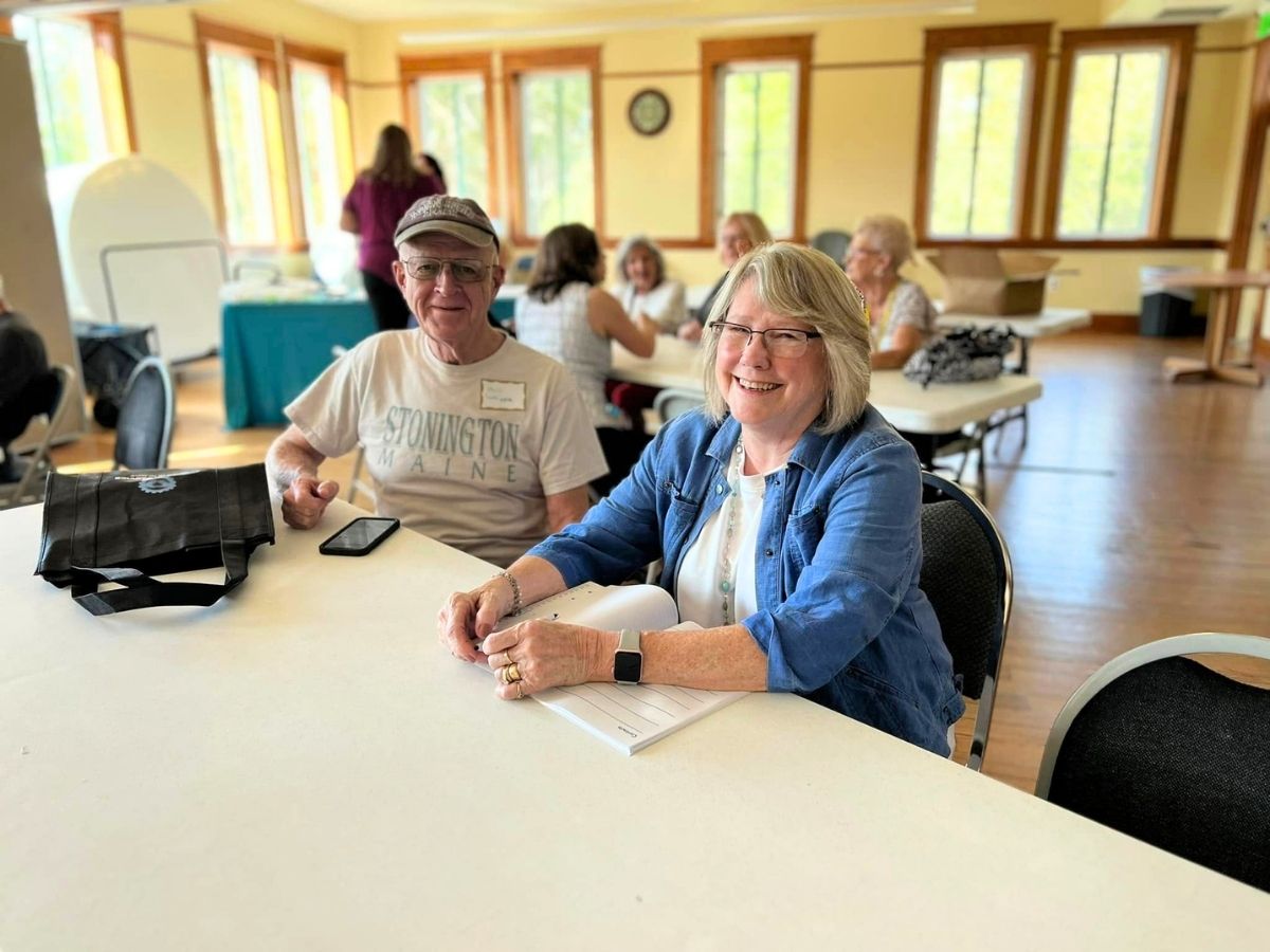 Volunteers sit together during a Geared Up Gathering appreciation event celebrating service and community connection.
