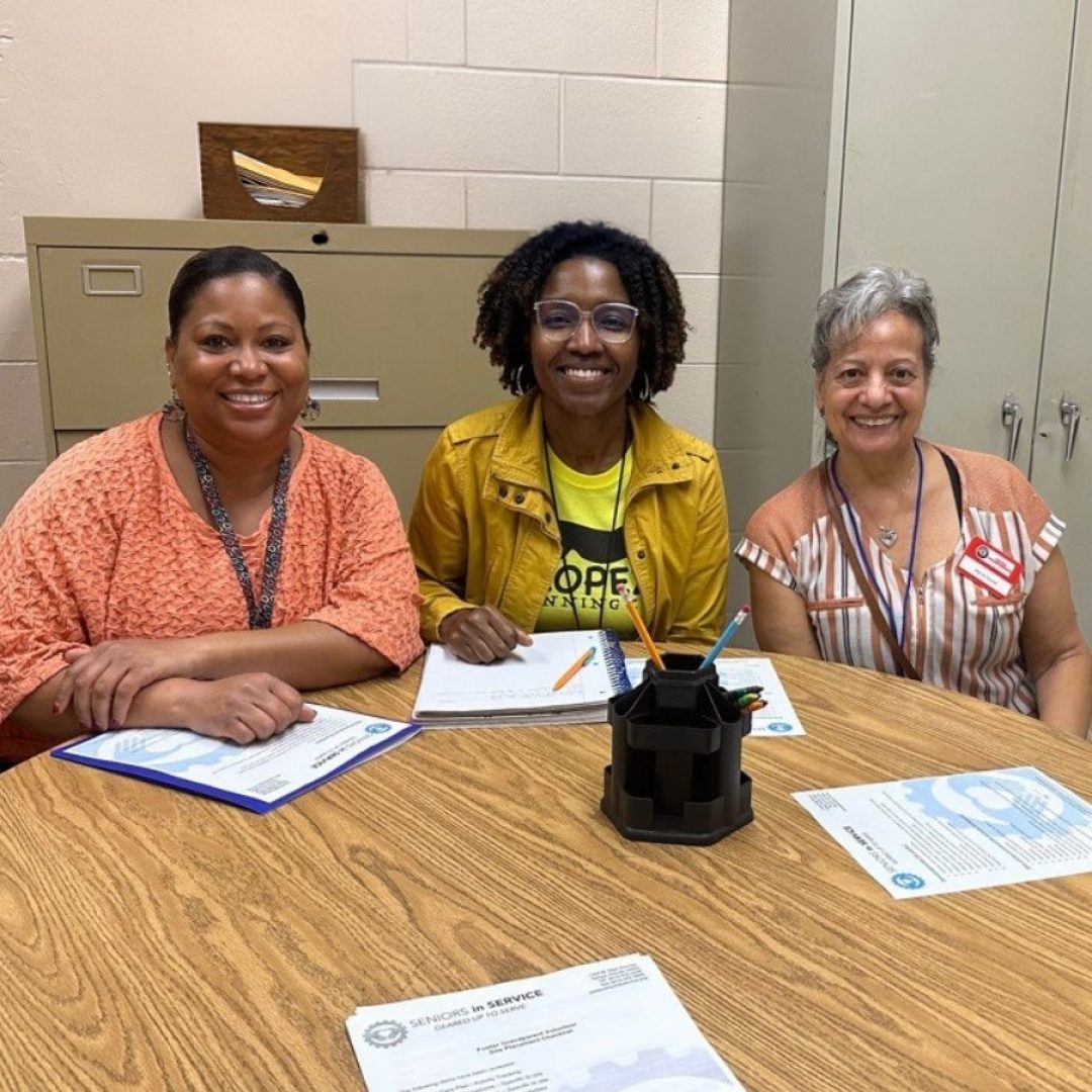 Classroom Grandparent volunteer Grandma Myrna and teacher Mrs. Litz pose together at an elementary school, celebrating a partnership that supports students and strengthens the school community.
