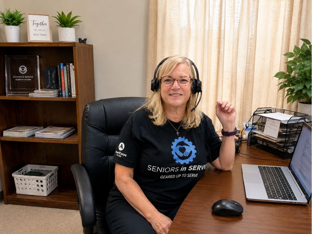 Health Buddies volunteer wearing a headset provides friendly phone companionship and wellness support to older adults in Tampa Bay.