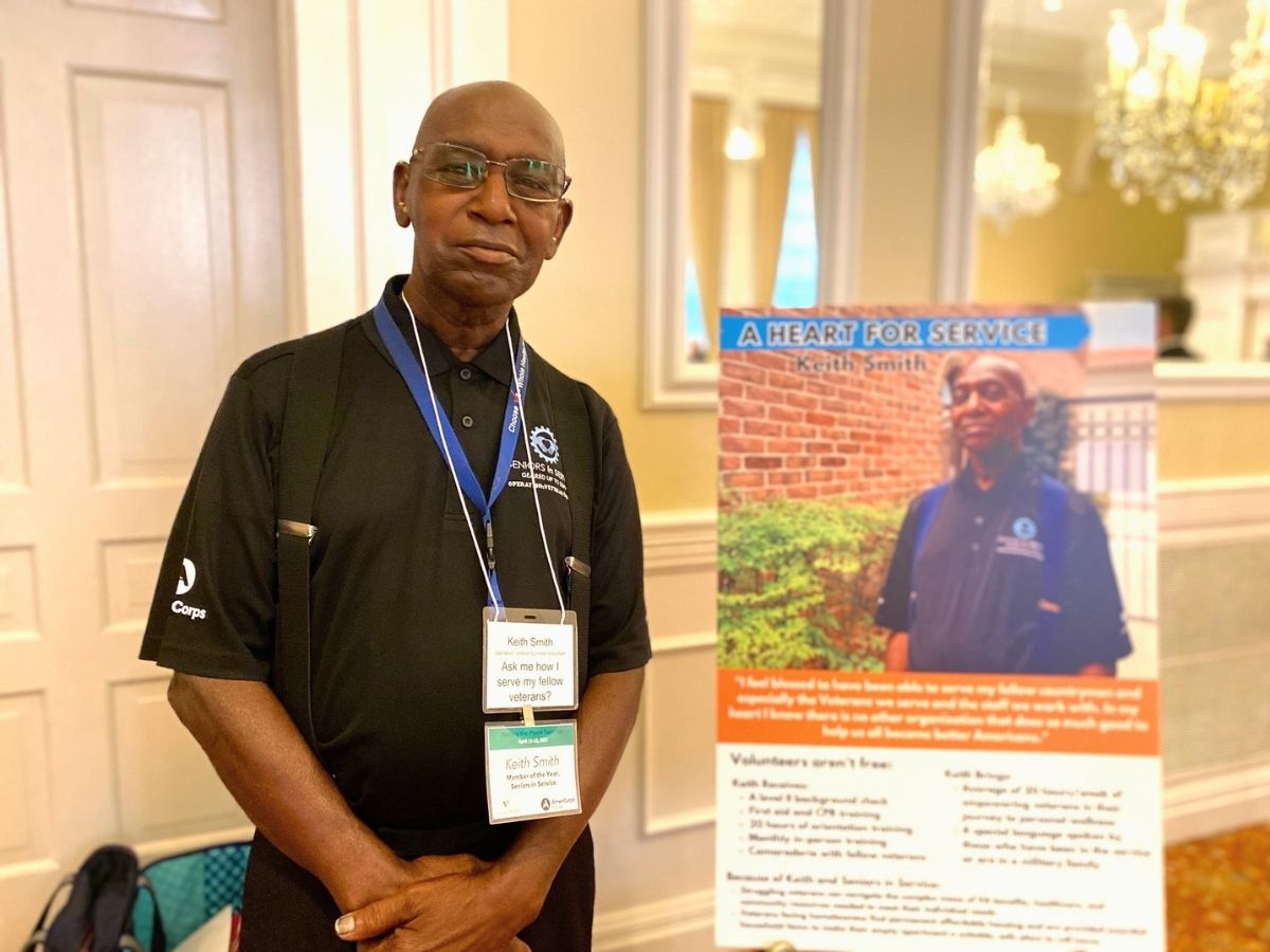 Operation: Veteran Connect volunteer Keith Smith stands beside a display recognizing his service and commitment to helping veterans.