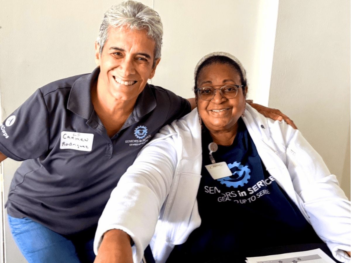 Senior Companion volunteer Lauren smiles with a fellow volunteer at the Gulfport Senior Center.