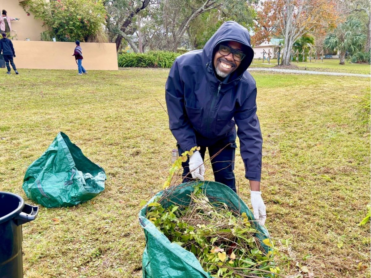 Volunteer removes yard debris during the MLK Day of Service at The Franciscan Center in Tampa.