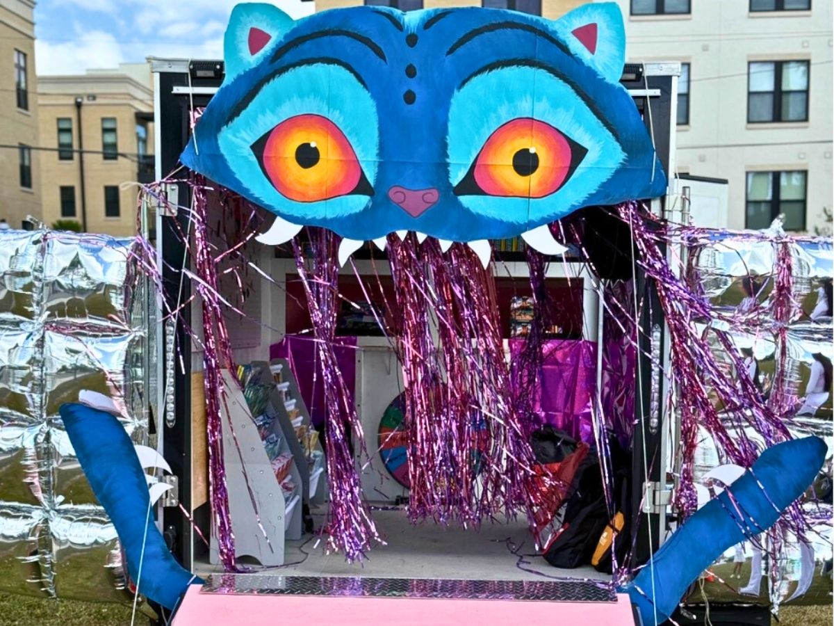 Seniors in Service mobile outreach trailer transformed into a colorful storybook entrance where children can choose free books during community literacy events.