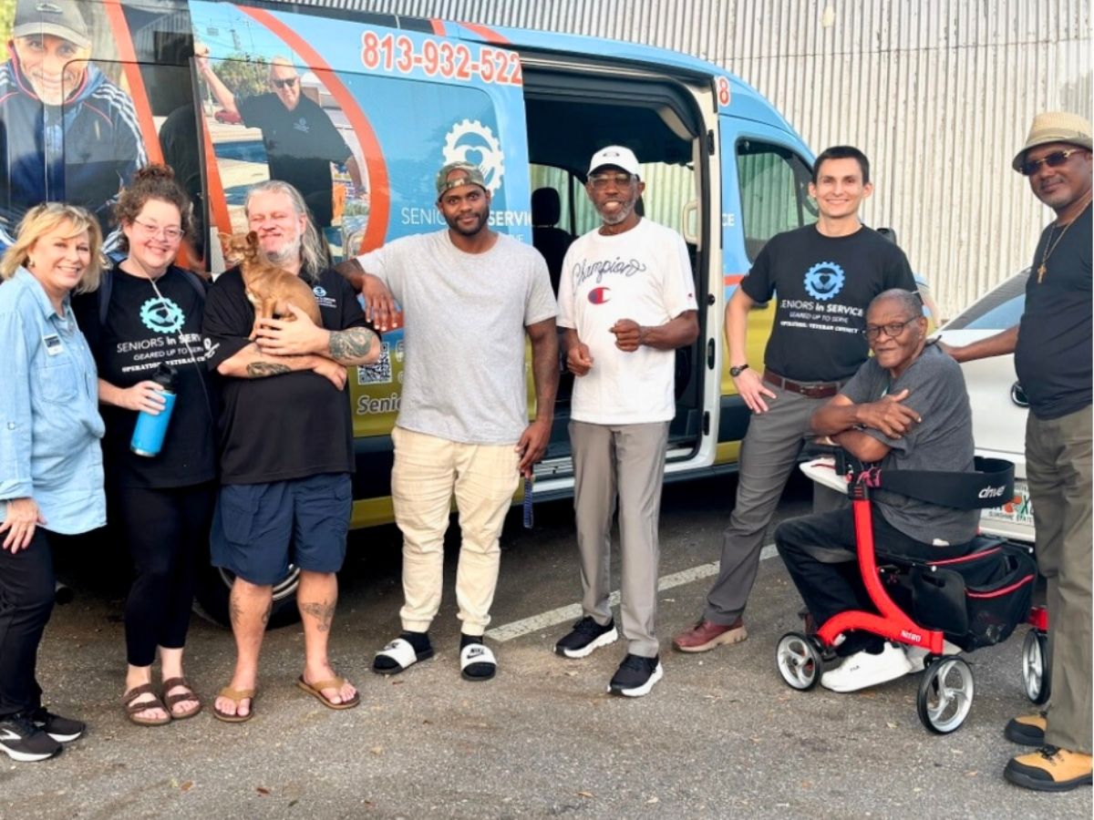 Seniors in Service staff, volunteers, veterans, and community members gather beside the new mobile outreach van that brings disaster support, educational resources, and veteran services directly into the community.