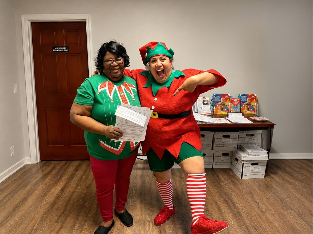 Nat the Elf celebrates the delivery of Winter Activity Books that help elementary students continue learning during winter break.