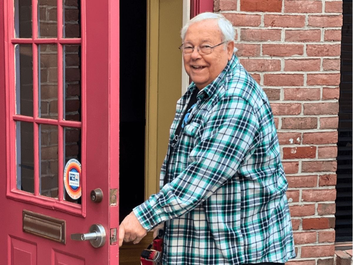 RSVP volunteer Peter opens the door to the Seniors in Service office after helping lead renovation and outreach improvement projects.