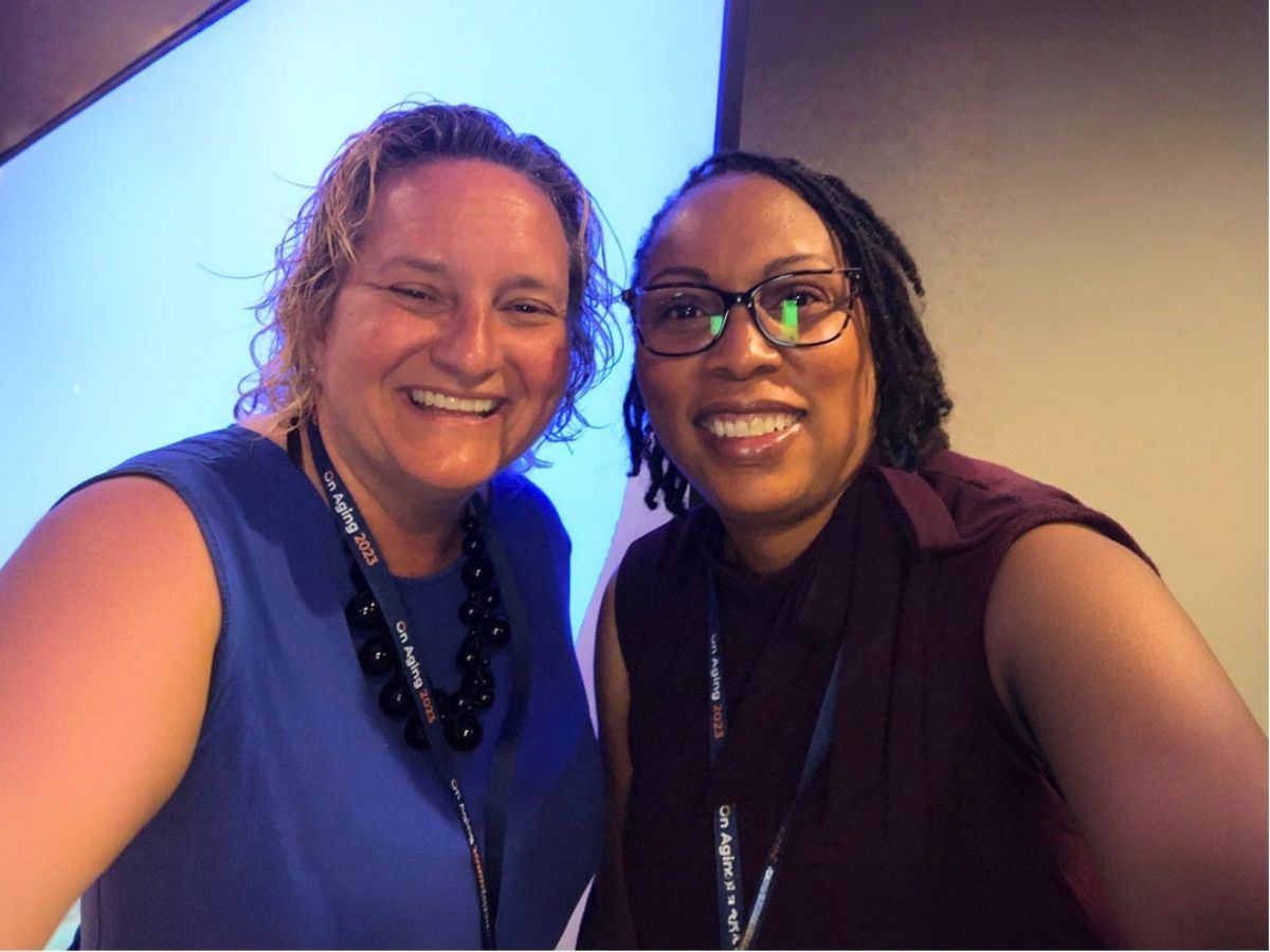 Seniors in Service CEO Robin Ingles with team member at a conference, representing intergenerational connection and community impact.