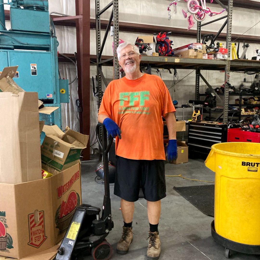 Seniors in Service volunteer Ron works in a warehouse handling donated items for community distribution.