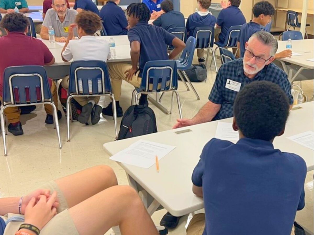 RSVP volunteer mentor speaks with middle school students during a mentoring session, helping build confidence, character, and life skills.