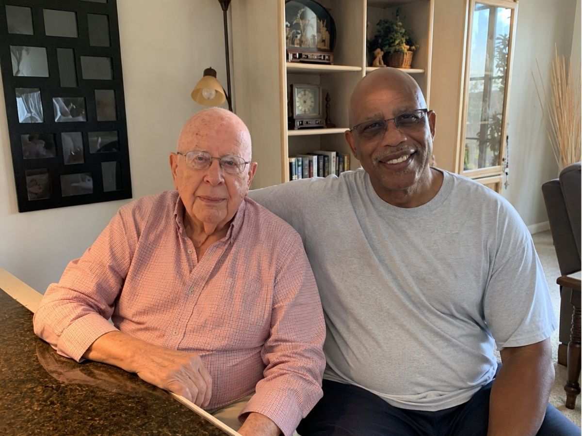 Senior Companion volunteer Herman Archie visits with client Murph in his home, providing companionship and support to help him remain independent.
