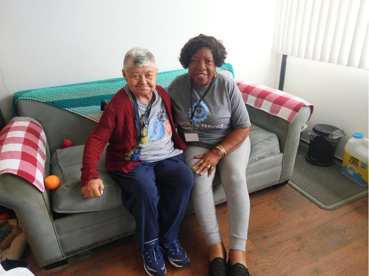 Senior Companion volunteers Shirley Hosey and Asleen Griffin share a smile while spending time together at Shirley's home.