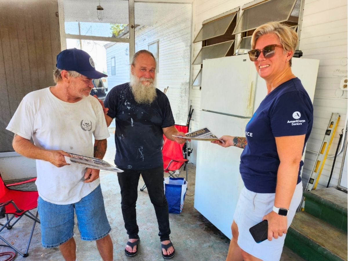 Volunteer distributes hurricane preparedness guides to older adults at a mobile home community in Pinellas County.