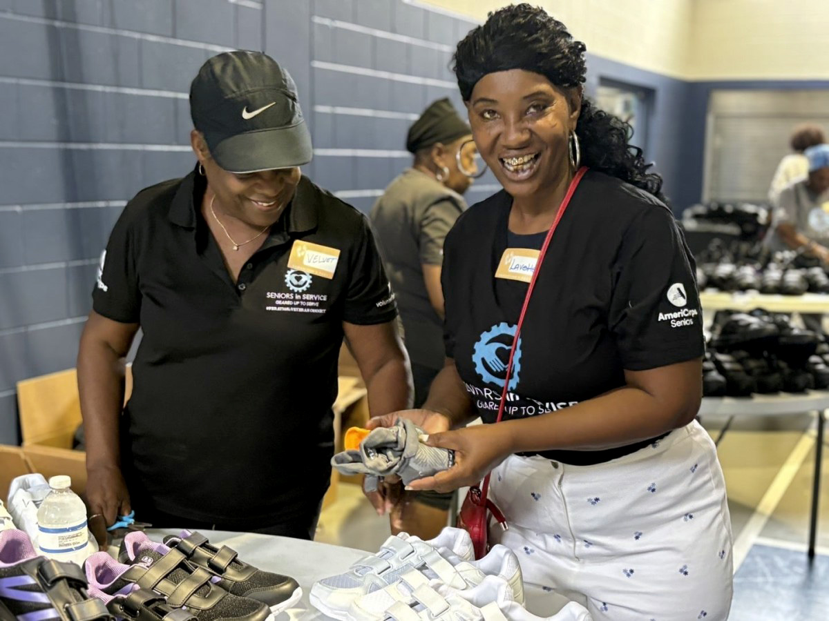 Volunteers assist seniors with selecting and fitting new shoes during a Samaritan's Feet community giveaway event.