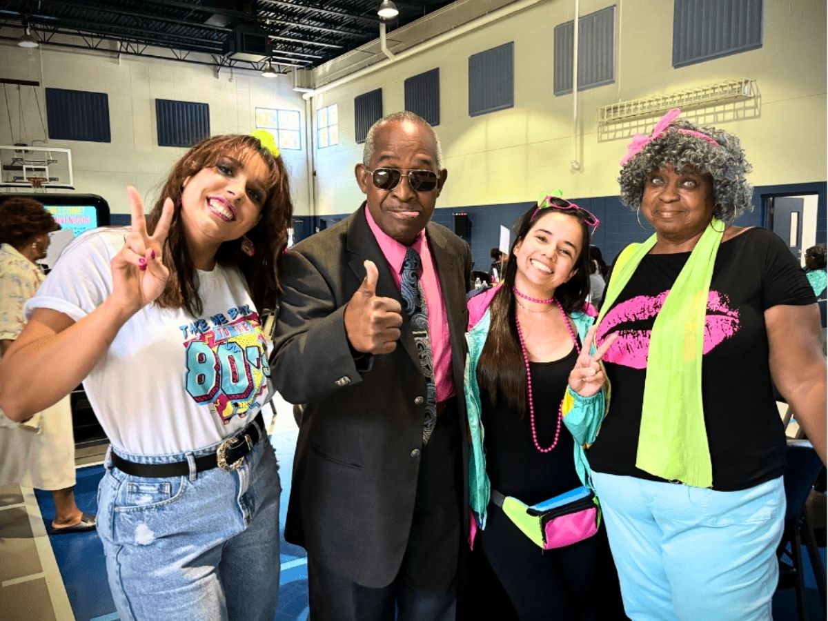 Seniors in Service volunteers dressed in colorful 1980s outfits celebrate the organization's 40th anniversary at a volunteer appreciation event in Tampa Bay.
