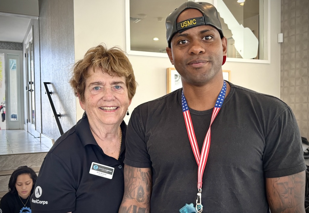 Seniors in Service Ambassador Anne smiling with a Veteran at a community event.