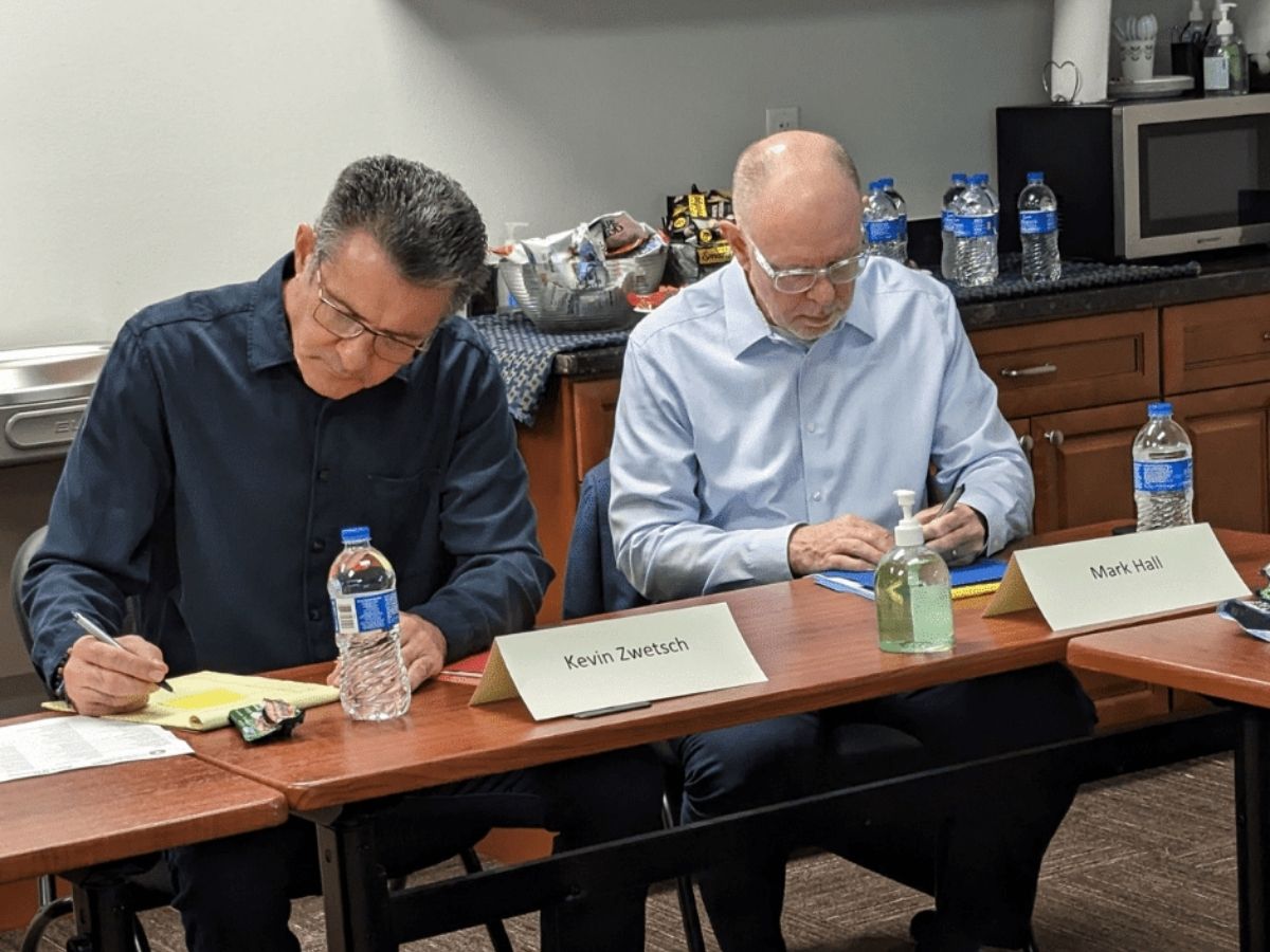 Seniors in Service board members Kevin and Mark take notes during board retreat training and strategic planning discussions.