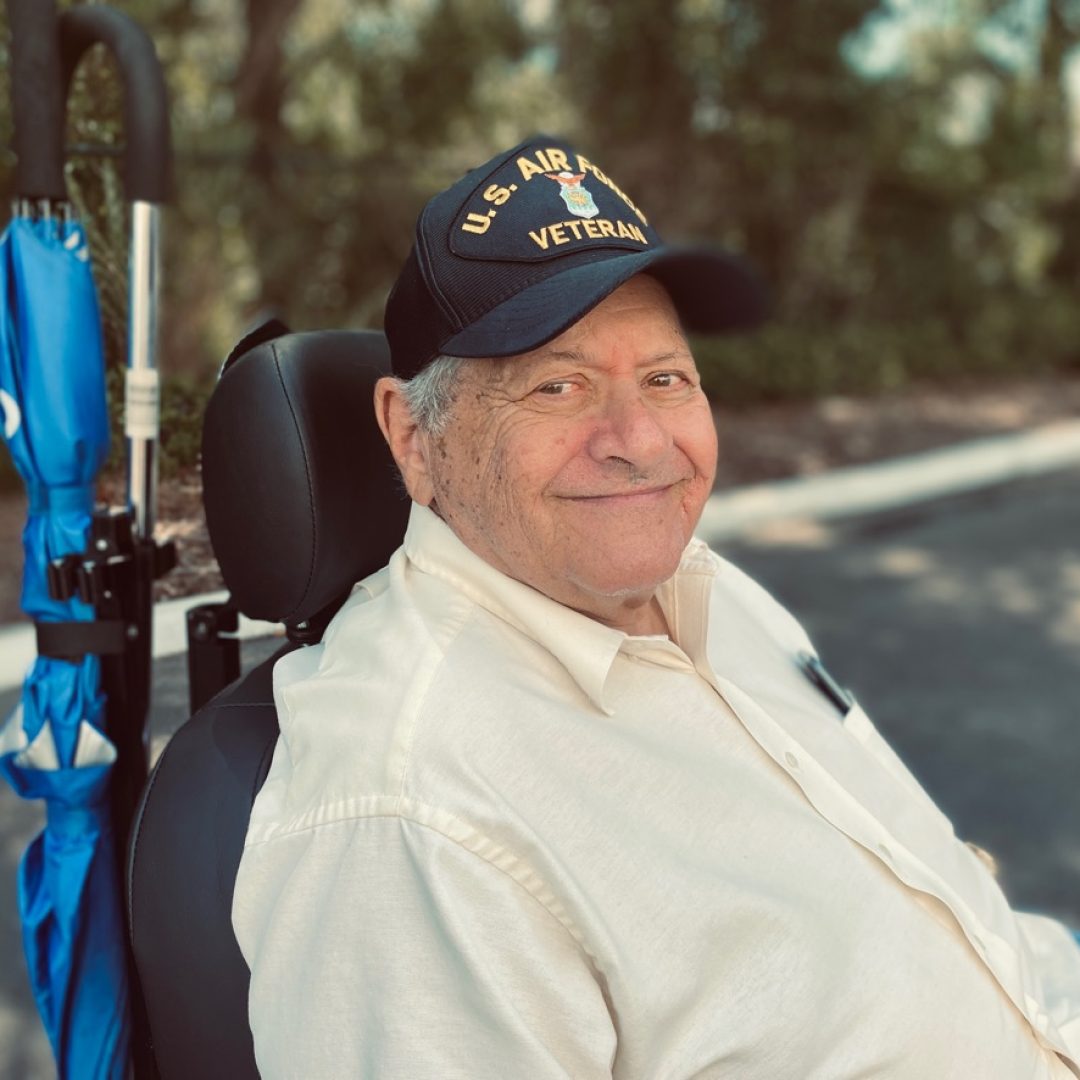 Seniors in Service Telepals program member and US Air Force veteran sits outside in his wheelchair.
