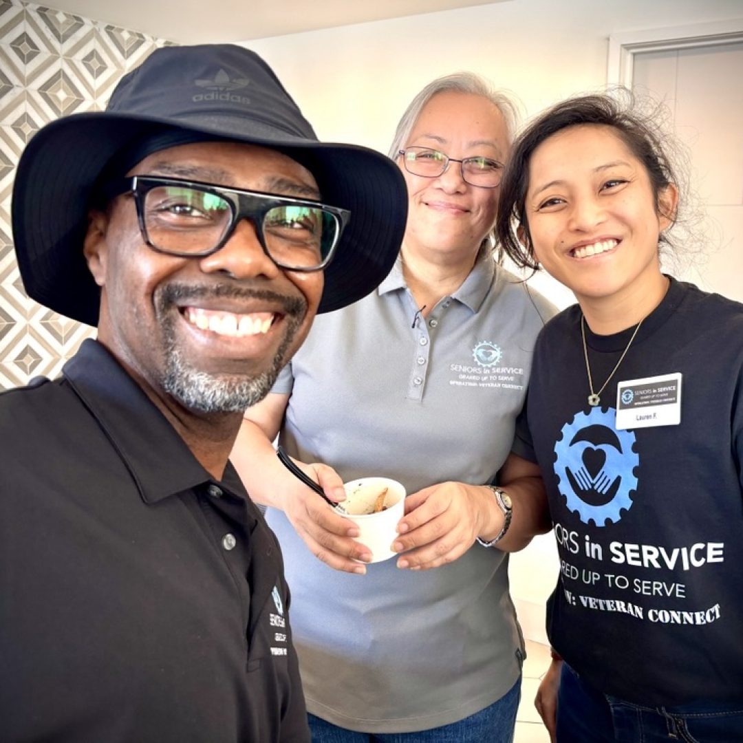 Seniors in Service Operation: Veteran Connect volunteers smile for a selfie while serving veterans at a community gathering.