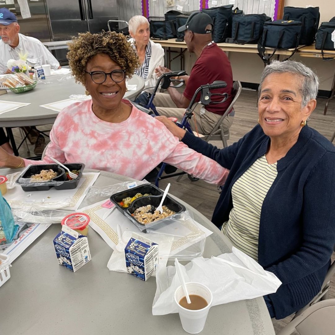 Seniors In Service Senior Companion volunteer connects with a Tampa Bay senior at a luncheon.