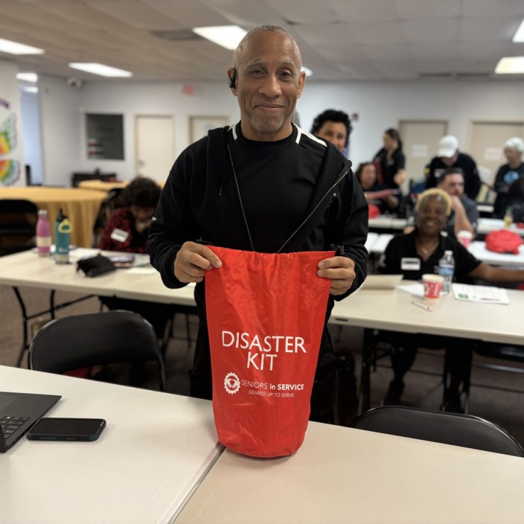 A Seniors in Service volunteer shows the branded Disaster Kit.