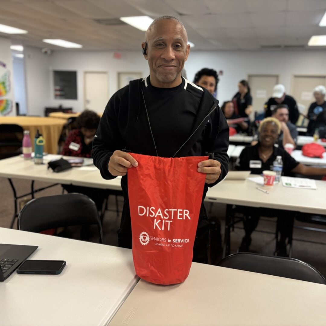 A Seniors in Service volunteer shows the branded Disaster Kit.