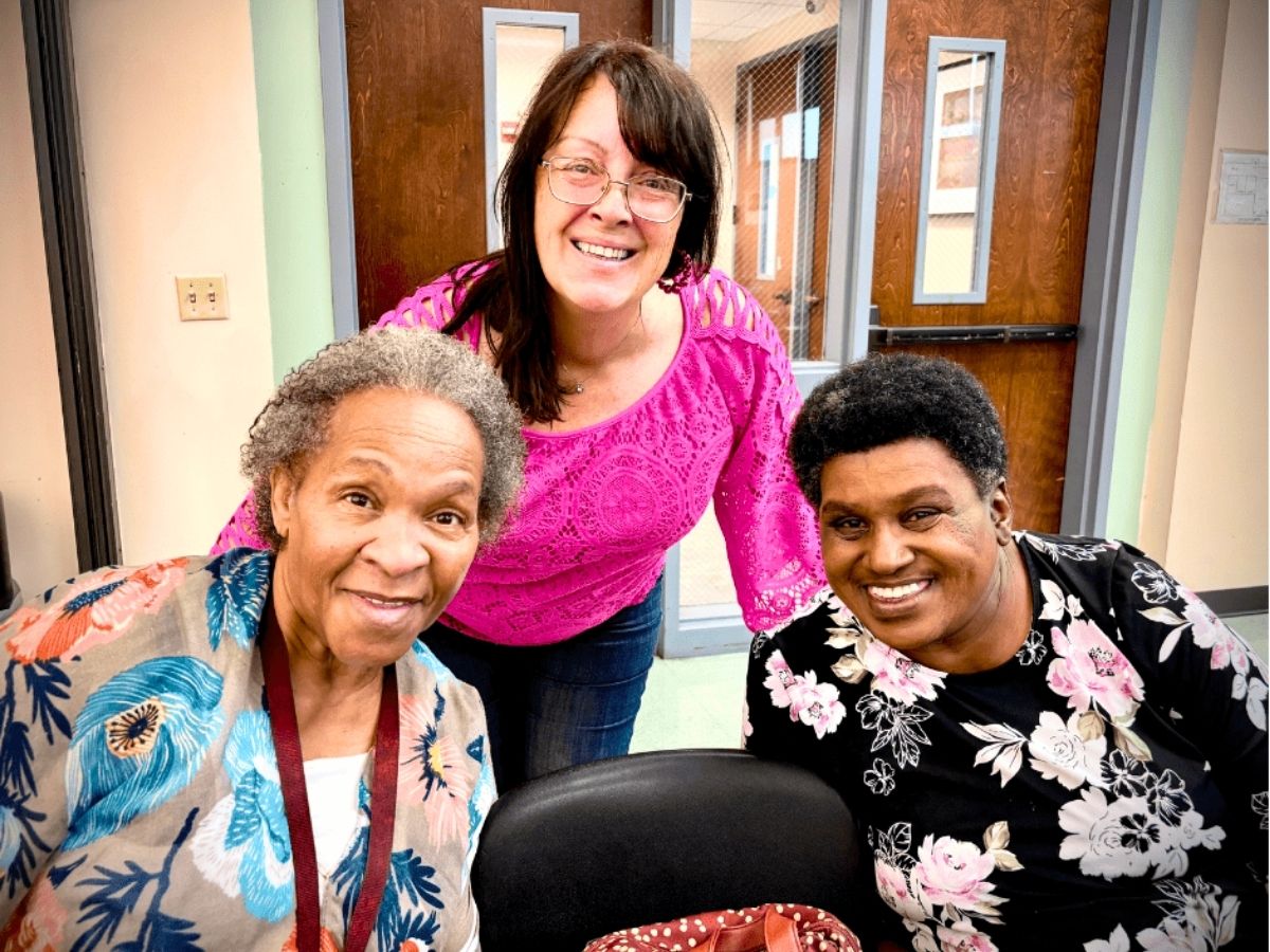 Three Seniors in Service volunteers smile together during the organization's 40th anniversary volunteer appreciation celebration.