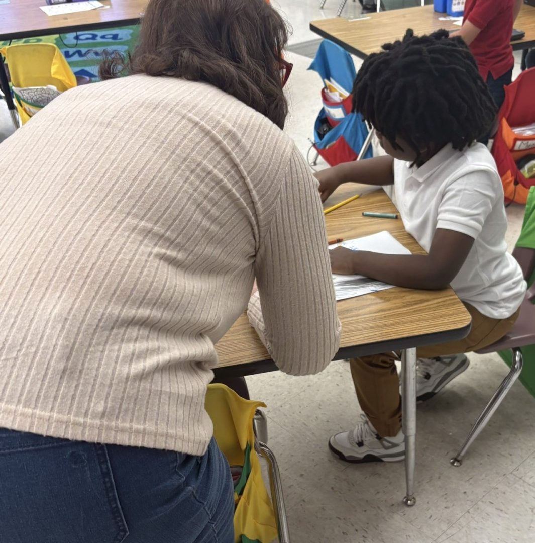 Volunteer Helps Young Student in the Classroom Seniors in Service volunteers helps a young student in the classroom.