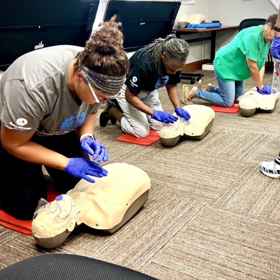 Seniors in Service volunteers practice on CPR Dummies while learning certified in lifesaving techniques.