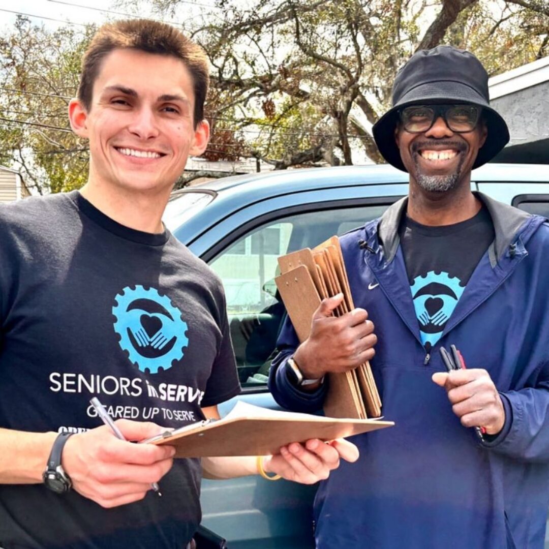 Seniors in Service staff member Greg with Operation: Veteran Connect member outside a community event.