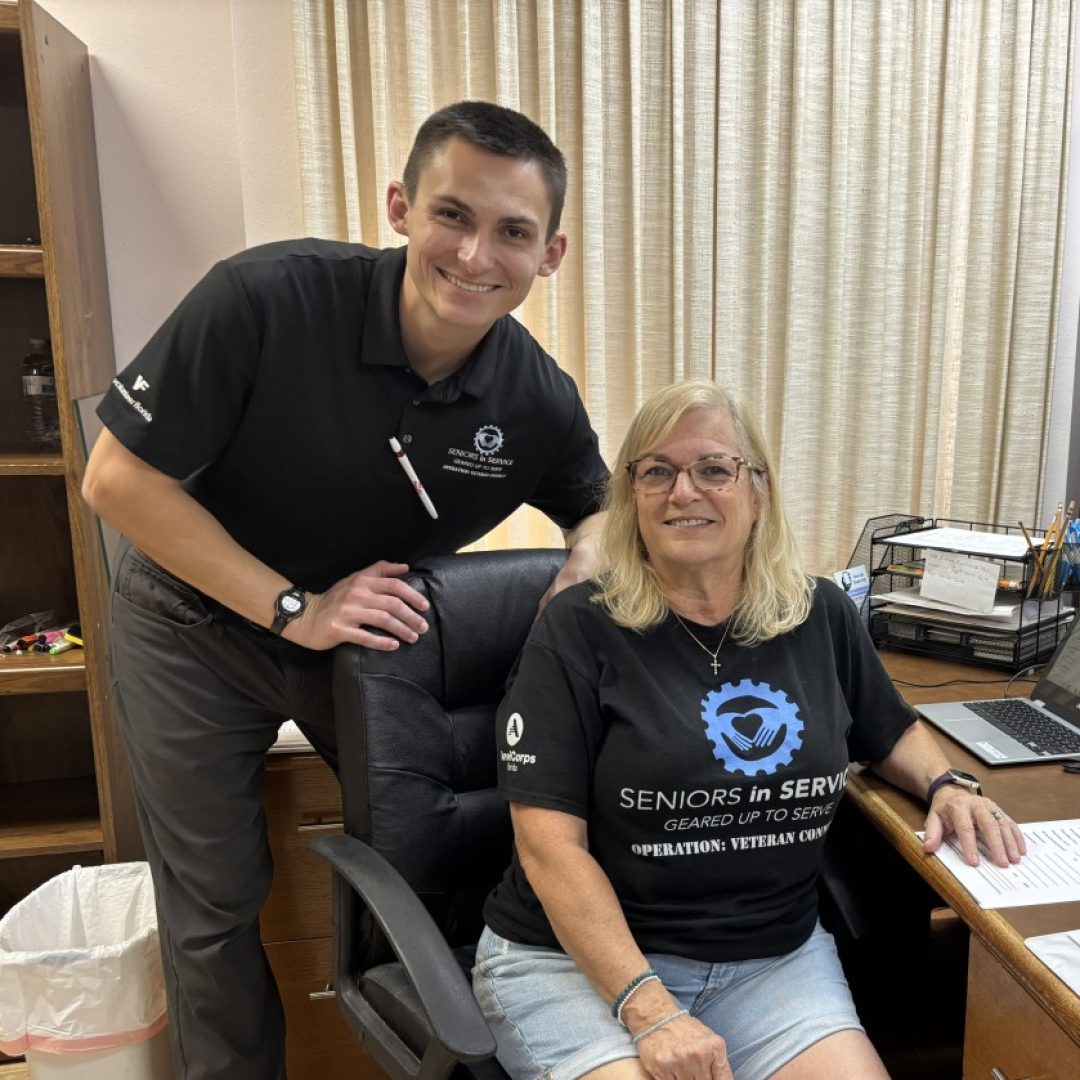 Volunteer helping a senior find local resources by phone.