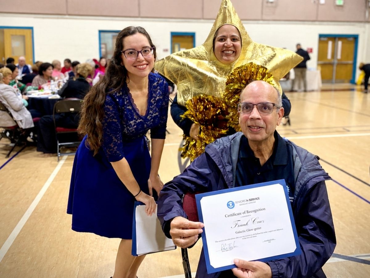Volunteer award recipient with event organizers and a gold star mascot during the Seniors in Service Volunteer Appreciation Luncheon.