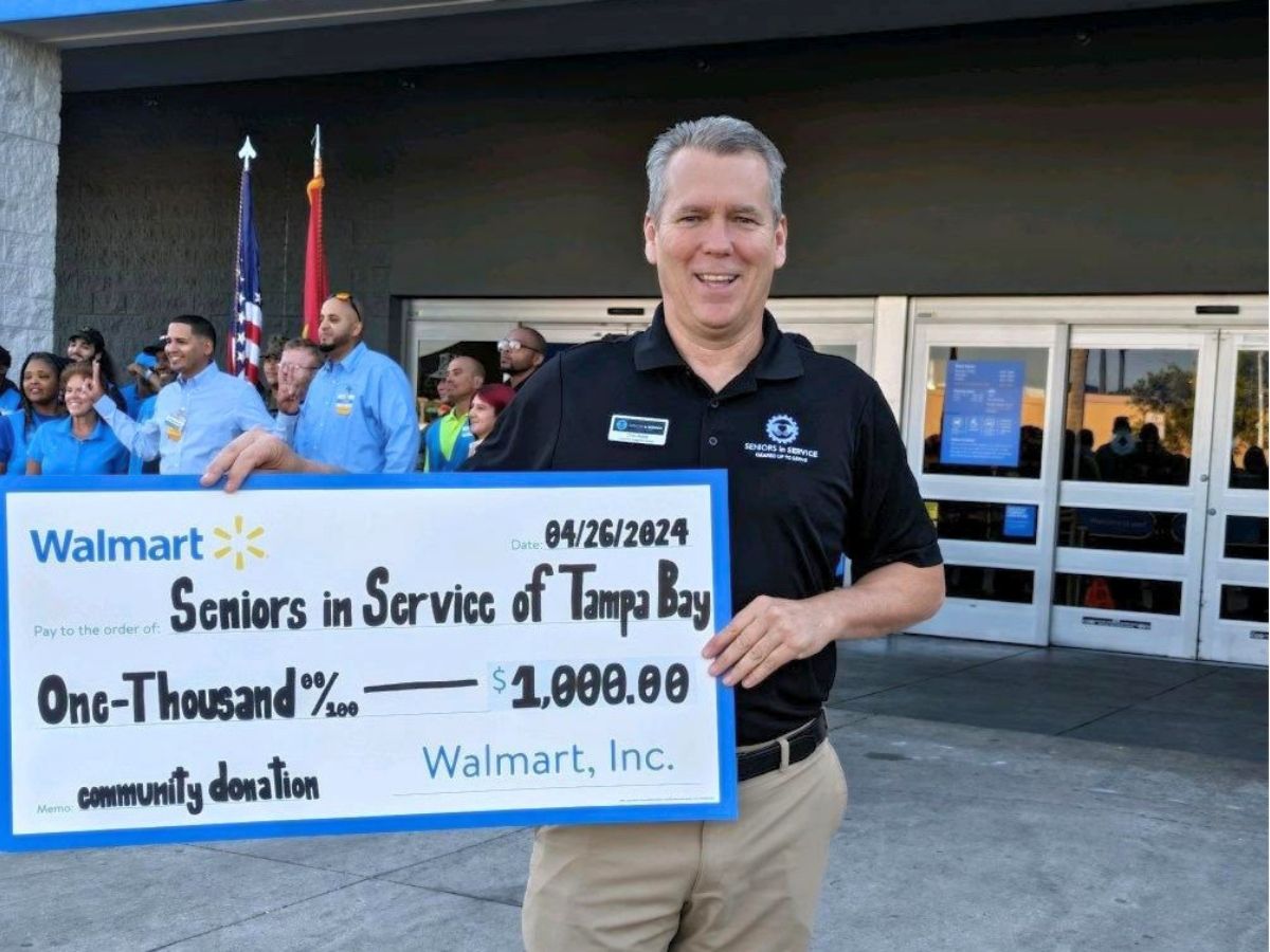 Chris Noble accepts large donation check from Walmart.