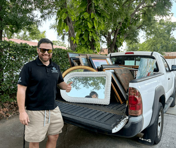 Operation: Veteran Connect volunteer unloads donated artwork and framed pictures for the Warm My Walls campaign supporting veterans moving into permanent housing.